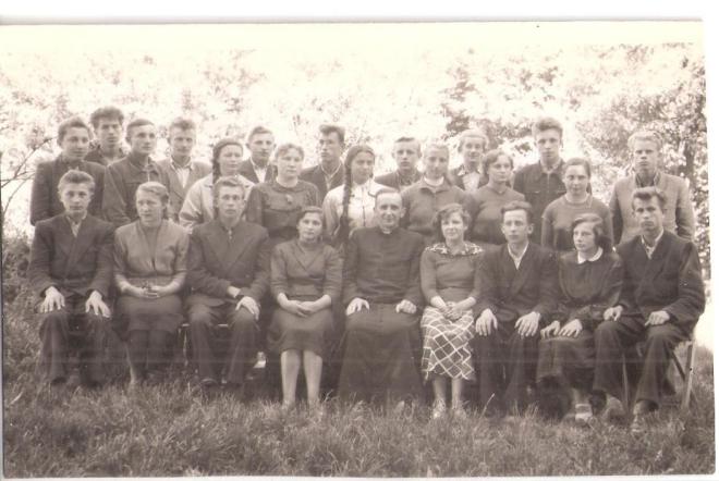 Od lewej strony stoją: Michaś Ostrówka, Władek  Mrozek, Stanisław Tabaka, Janek Wyżykowski, Irenka Milanowska, Rysiek Grabowski, Stasia Drężek, Kazik Płachta, Józia Falenta, Janek Archutowski, Basia Florek, Zbyszek Nasiłowski, Stasia Bączek, Czesiek Drężek, Zosia Duszak, Kazik Piaścik oraz siedzący od lewej Józek Niksa, Maryla Dopierała, Janek Tomaszewicz, Marysia Pietraszek, ksiądz Siedlecki, Anka Truskowska, Władek Kowalewski, Renia Zienkiewicz i Michaś Smut.